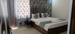 SHEHNAI RESORT Hotel & Restaurant في Jāmb: غرفة نوم مع سرير مع اللوح الأمامي والوسائد