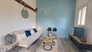 un salon avec un canapé et une télévision dans l'établissement Le cocon Tarbais, à Tarbes