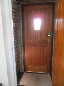 a wooden door with a light on a brick wall at Riverside Lodge At Bridge Stores in Great Yarmouth