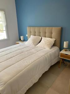 a large white bed in a bedroom with a blue wall at Villa Ibisa in Angles