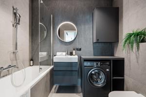a bathroom with a washing machine and a sink at Scala City Center Premium Apartments with Parking by Lion Apartments in Gdańsk +58 photos