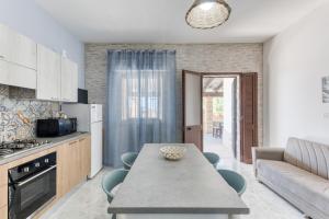 Una cocina y una sala de estar con una mesa y un sofá. en Villetta Marchese, en Salve