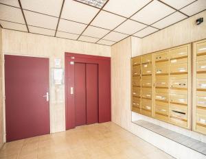 Habitación grande con taquillas de madera y puerta roja. en Le Reflet Secret - Hypercentre - Balnéo, en Troyes