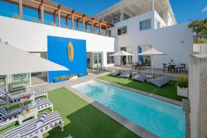 a building with a pool with chairs and tables at One Marine Drive Boutique Hotel & Spa by The Living Journey Collection in Hermanus