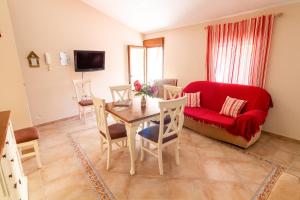 ein Wohnzimmer mit einem roten Sofa und einem Tisch in der Unterkunft Apartamentos Rurales Tía María in Mata de Alcántara