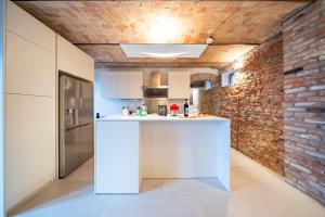 Una cocina con encimera blanca y pared de ladrillo. en Casa Bianca, en Castelnuovo