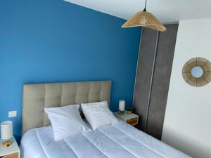 a blue bedroom with a bed with white pillows at Villa Ibisa in Angles