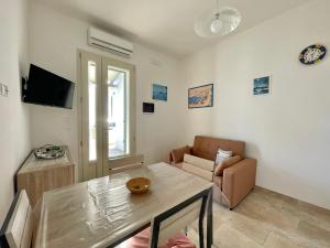 a living room with a table and a couch at CASA MELODIA - immersa negli uliveti con vista sul mare Ionio in Marina San Gregorio