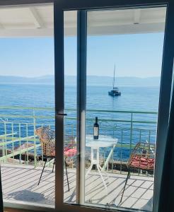 a view of the ocean from a balcony with a table and chairs at Avra Benitses Beach Apartment in Benitses
