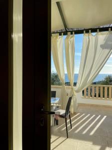 a view of a balcony with a chair and a window at CASA MELODIA - immersa negli uliveti con vista sul mare Ionio in Marina San Gregorio