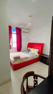 Kampong Bukit BungaBUKIT BUNGA Inn的一间设有红色床和窗户的小卧室 更多3张照片