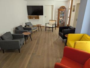 a waiting room with couches and chairs and a flat screen tv at Wein und Stein in Randersacker
