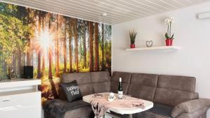 a living room with a couch and a forest mural at Ferienhaus für drei Personen mit Terrasse in Friedrichroda