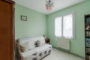 Una sala de estar con un sofá y una ventana. en Fantasia - Parking - Pet friendly, en Mindin