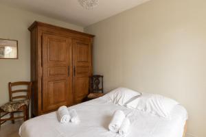 Un dormitorio con una cama blanca con toallas. en Fantasia - Parking - Pet friendly, en Mindin
