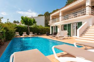 a swimming pool with chairs and a house at Villa Ana by Escape Home in Santo Tomás