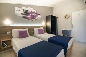 A bed or beds in a room at Affittacamere Orchidea for Tourists Hesperia Hosp
