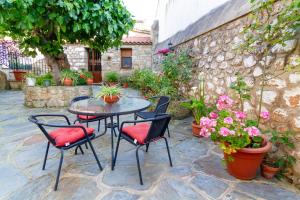 eine Terrasse mit Tisch und Stühlen und Blumen in der Unterkunft Apartamentos Rurales Tía María in Mata de Alcántara
