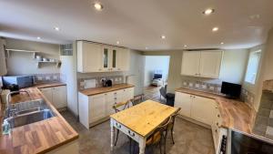 Salisbury Garden Apartment 3 beds 2 baths في Shrewton: مطبخ كبير مع طاولة خشبية و sidx sidx