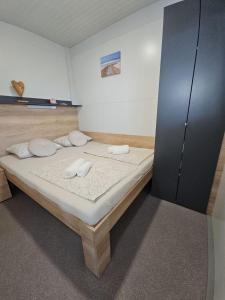 a bedroom with a large bed with white pillows at Rock Mobile Home in Sveti Petar