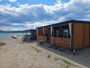 a couple of huts on a beach next to the water at Rock Mobile Home in Sveti Petar