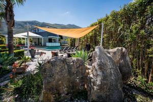 a patio with two large rocks in a yard at Moresca Exclusive Villa - Pool & Spa in Castellammare del Golfo