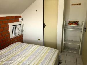 a small bedroom with a bed and an open door at Casa com piscina in Gravatá