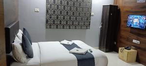 um quarto com uma cama branca e uma tv em Hotel Grand View - Pimple Saudagar em Chinchwad