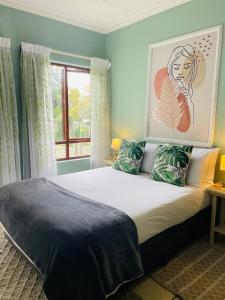 a bedroom with a bed with a painting on the wall at 361 On Sunset in Sandton