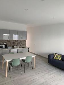 cocina con mesa, sillas y sofá en Casa Jonhy, en Faro