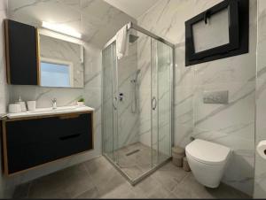 a bathroom with a shower and a toilet and a sink at Caesar Resort Atilius in Trikomo +16 photos