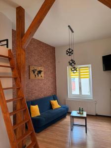 a living room with a blue couch and a brick wall at Apartamenty w centrum Wawel & Smok AC Progres in Toruń