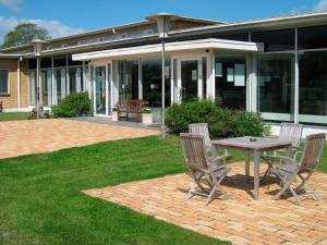 a patio with a table and chairs in front of a building at Hotel Nørherredhus in Nordborg