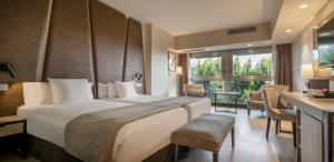 pokój hotelowy z dużym łóżkiem i biurkiem w obiekcie Ilunion Málaga w Maladze