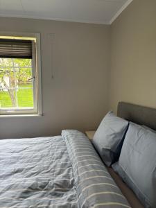 an unmade bed in a bedroom with a window at Magnhilds Luxury Apartment in Otta