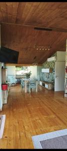 a large room with wooden floors and a table and chairs at A Casa di Alice Assisi in Santa Maria degli Angeli