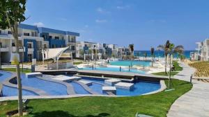 a resort with a large swimming pool next to the ocean at Fouka bay service appartment FOR Families only in Marsa Matruh