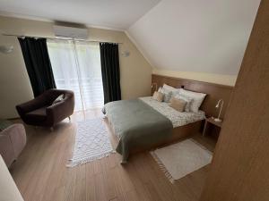 a bedroom with a bed and a chair and a window at House Biba & Leona in Rastovača +53 photos