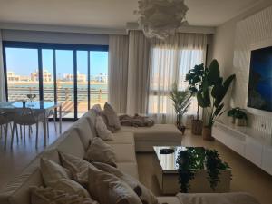 a living room with a white couch and a table at El Gouna - 3 Bedroom - Rooftop-Pool - Ancient Hill in Hurghada