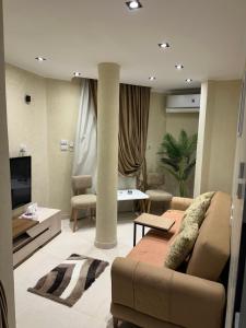 a living room with a couch and a tv at Temple & Nile view in Luxor