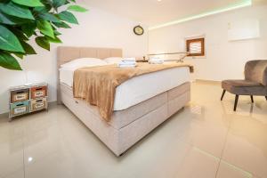una camera da letto con un letto grande e una sedia di Apartment Porto with Terrace a Baška