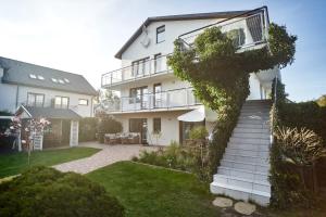 a white house with a staircase in the yard at SKiPER Dębki in Dębki