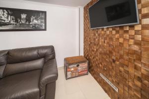 un soggiorno con divano e TV su un muro di mattoni di Apartment Porto with Terrace a Baška