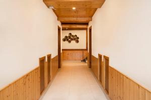 a hallway with white walls and a wooden ceiling at Treebo Premium Sattva With Mountain View in Manāli