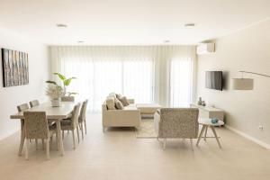 a white living room with a table and chairs at Paraiso da Foz Residence - BY SCH in Foz do Arelho