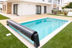 a swimming pool with a slide in a yard at Paraiso da Foz Residence - BY SCH in Foz do Arelho