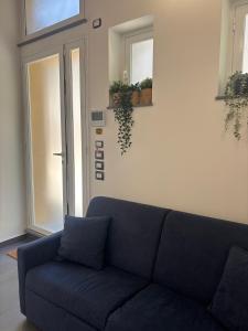 a blue couch in a living room with a window at Cortiletto Pavone A in Catania
