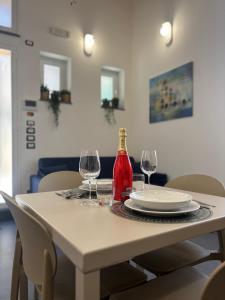 a table with glasses and a bottle of wine on it at Cortiletto Pavone A in Catania
