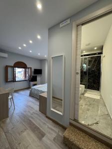 a bedroom with a bed and a bathroom with a mirror at Casa Calipso in Catania