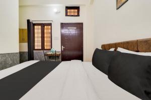 a bedroom with a bed and a wooden door at Hotel O Second Home Residency in Dehradun +21 photos